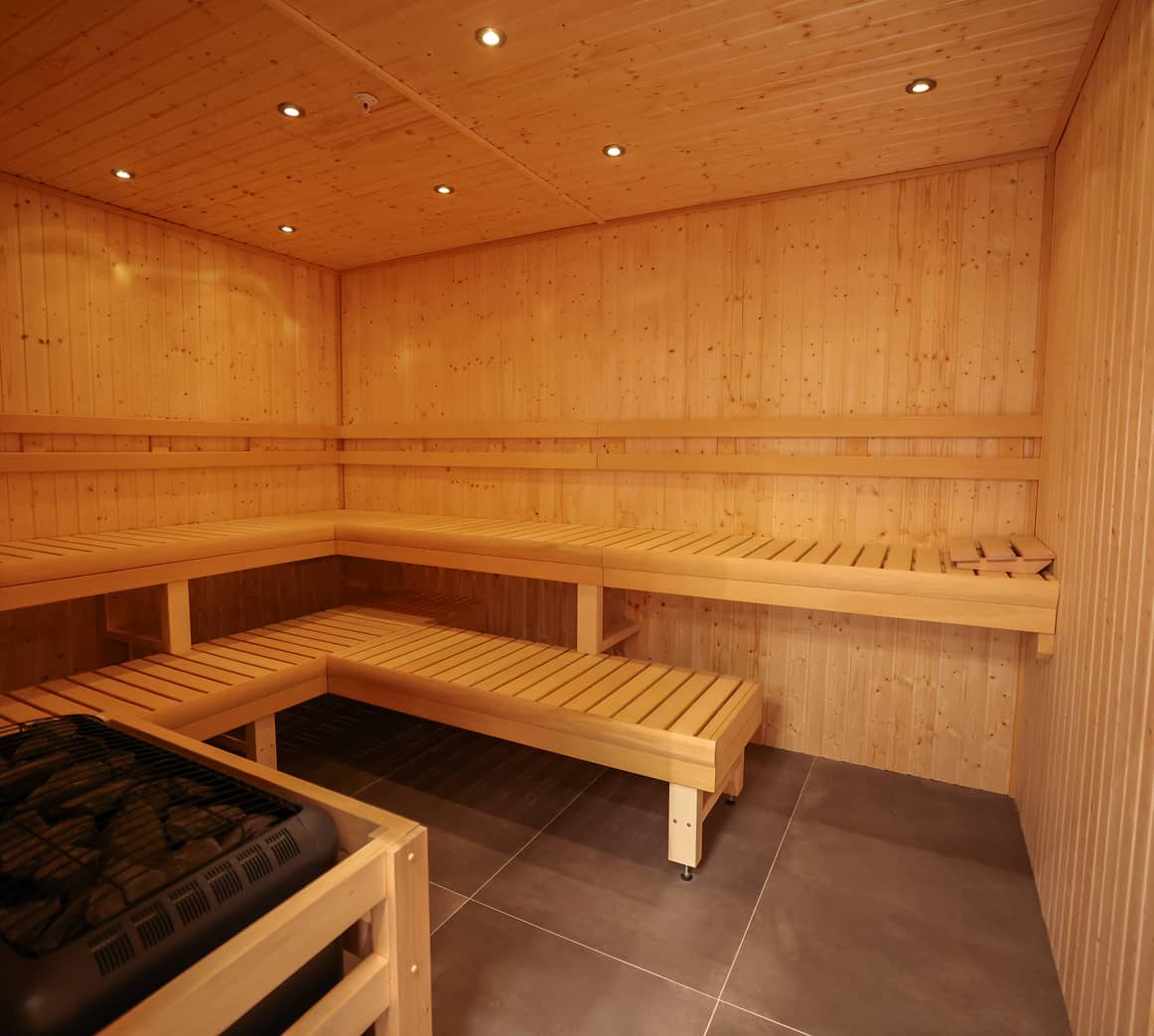 Sauna inside Absolute Recomp Frisco with wood interior and bench seating