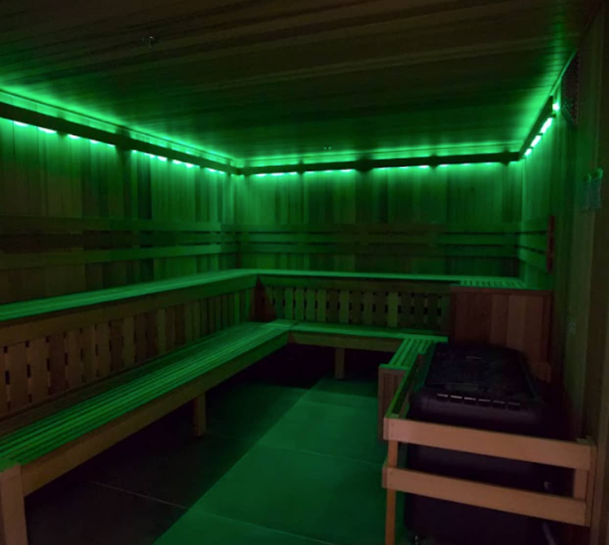 Sauna inside Absolute Recomp Las Colinas with wood interior and green lighting
