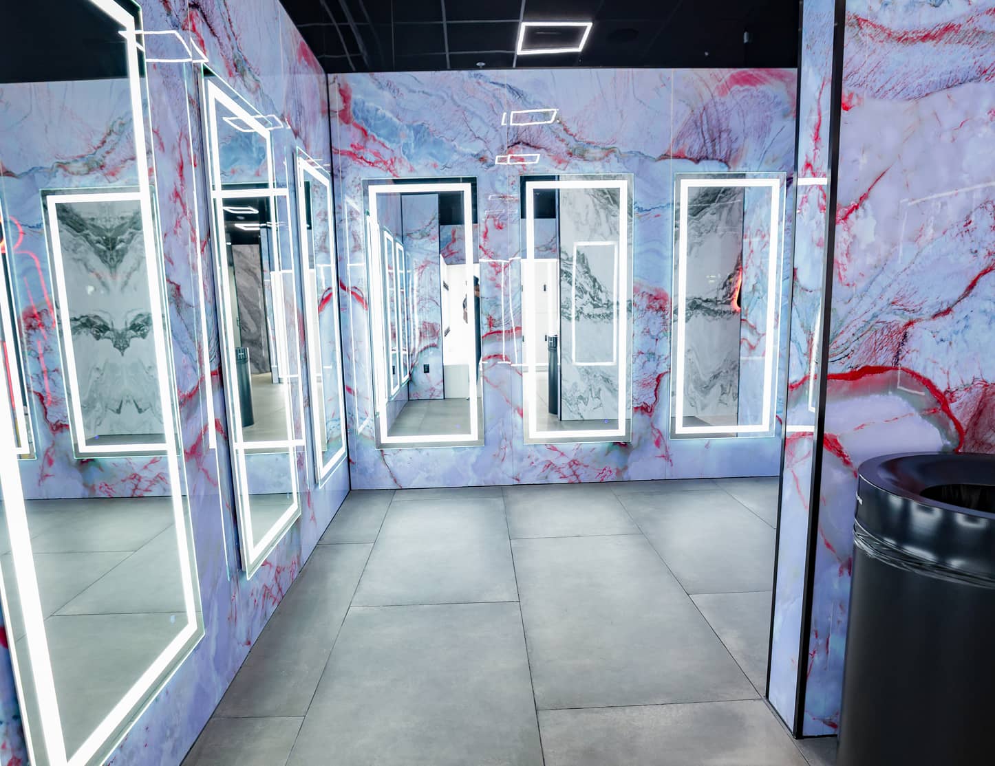 Locker room mirrors at Absolute Recomp Lewisville with illuminated frames and marble wall finishes