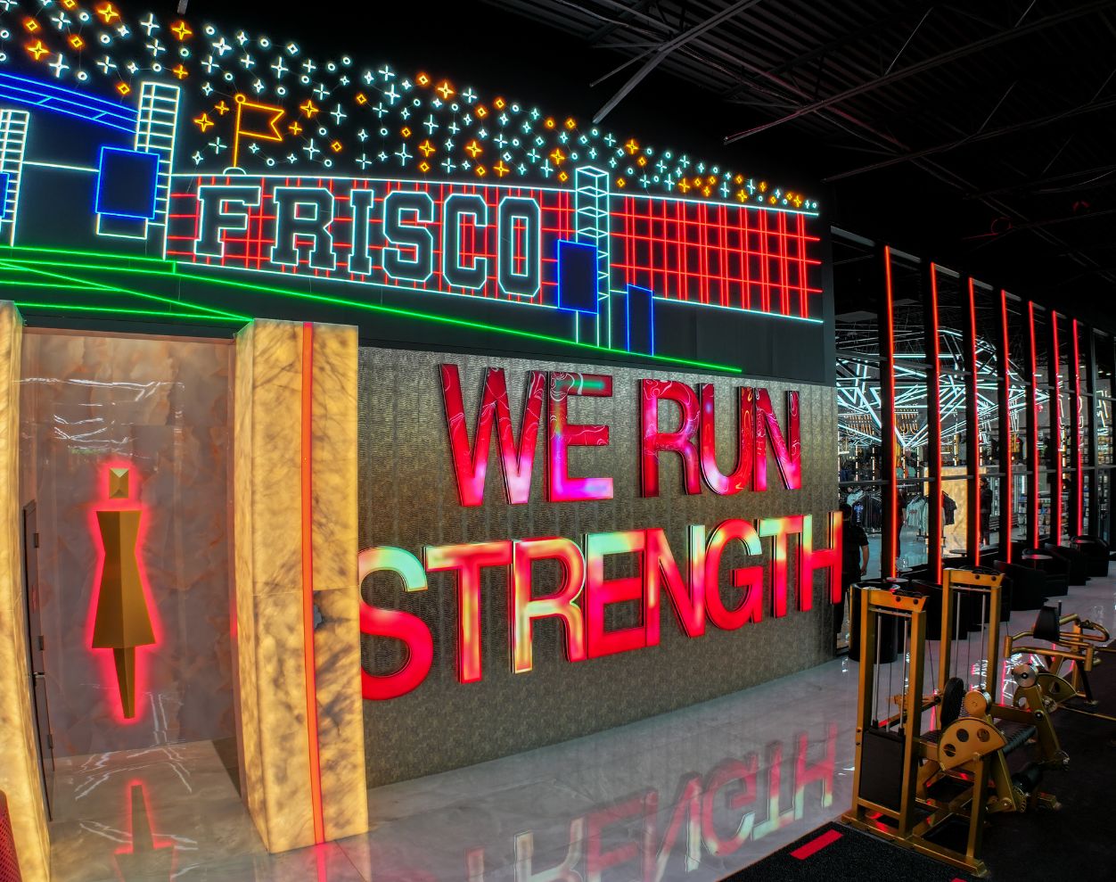 Neon posing room entrance and We Run Strength feature wall at Absolute Recomp Gyms Frisco